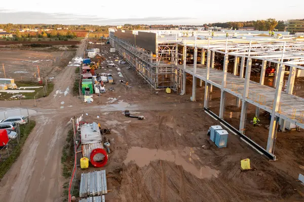 Sonbahar güneşli sabahları inşaat makineleri ve inşaat işçileri olan büyük ticari binaların inşaat alanlarının insansız hava aracı fotoğrafları.