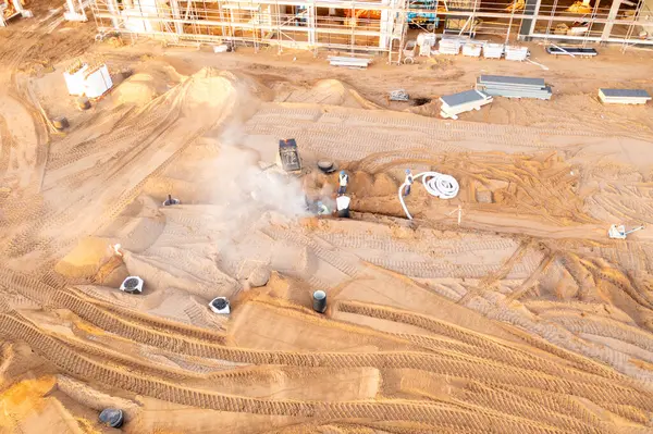 Sonbahar güneşli sabahları inşaat makineleri ve inşaat işçileri olan büyük ticari binaların inşaat alanlarının insansız hava aracı fotoğrafları.