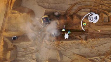 Sonbahar güneşli sabahları boru hattını döşeyen inşaat makineleri ve inşaat işçilerinin inşa ettiği büyük ticari binanın insansız hava aracı görüntüleri.