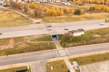 Otoyolun altından geçen yeraltı yayaların ve güneşli sonbahar günlerinde hareket halindeki bulanık arabaların insansız hava aracı fotoğrafları.