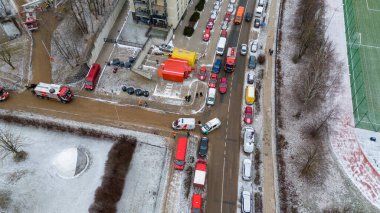 Kışın bulutlu bir günde, yanan bir binanın yakınındaki acil durum kontrol noktasının insansız hava aracı fotoğrafları.