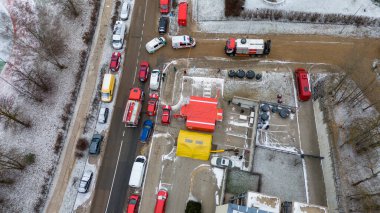 Kışın bulutlu bir günde, yanan bir binanın yakınındaki acil durum kontrol noktasının insansız hava aracı fotoğrafları.