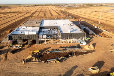 Sonbahar güneşli bir günde tarlalardaki depo inşaatının insansız hava aracı fotoğrafları.
