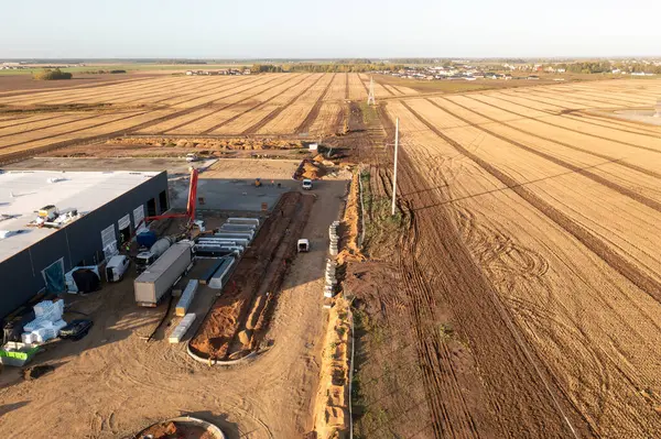 Drone photography of warehouse construction site in the fields during autumn sunny day
