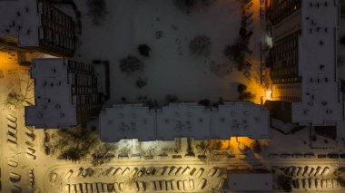 Kış bulutlu gecelerde bir apartman bloğunun ve oyun alanının drone fotoğrafçılığı