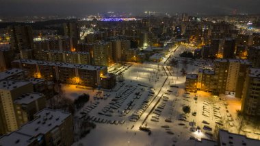 Apartman bloklarının, caddelerin ve kış bulutlu sabahlarında karla kaplı otoparkların insansız hava aracı fotoğrafları.
