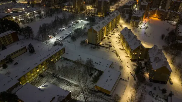 Apartman bloklarının, caddelerin ve kış bulutlu sabahlarında karla kaplı otoparkların insansız hava aracı fotoğrafları.