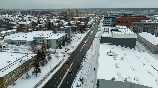 Drone photography of a city, street and buildings covered by snow during winter cloudy day