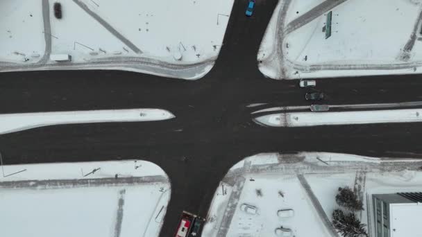 冬の吹雪の間に運転する都市と車の交差点のドローン映像 — ストック動画