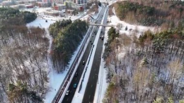 Halka açık orman parkının insansız hava aracı görüntüleri, trafiği olan yol ve kış güneşli bir günde çok katlı eski evler.