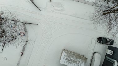 Kış bulutlu bir günde şehirde karla kaplı küçük otoparkın insansız hava aracı fotoğrafçılığı
