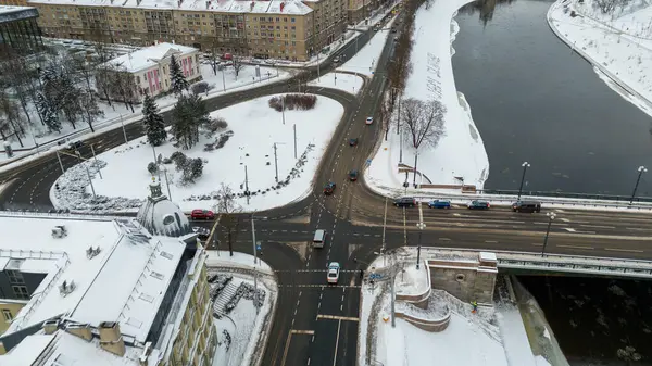 Drone photography of police escort driving through city traffic during winter cloudy day