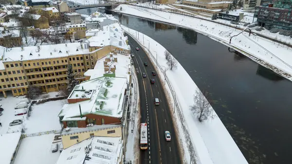 Drone photography of police escort driving through city traffic during winter cloudy day