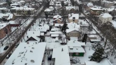 Kışın bulutlu bir günde kar ve ana cadde trafiği ile kaplanmış şehir manzarasının insansız hava aracı görüntüleri