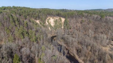 Kırsal arazinin insansız hava aracı fotoğrafları, halka açık park, baharın güneşli günlerinde küçük dağ ve nehir.
