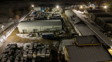 Geceleri metal geri dönüşüm tesisinin insansız hava aracı fotoğrafları ve kış bulutlu gecelerde yığınla metal.