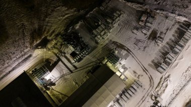 Kışın bulutlu gecelerde açık hava malzeme deposunun insansız hava aracı fotoğrafçılığı