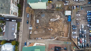 Güneşli bahar gününde diğer binalarla çevrili bir yerde inşaat alanının insansız hava aracı fotoğrafları.