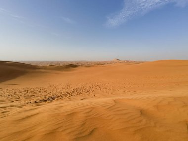 Baharın güneşli günlerinde Dubai yakınlarındaki Birleşik Arap Emirlikleri 'ndeki kızıl çöl kumullarının fotoğrafları