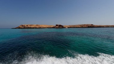 Muscat yakınlarındaki Umman 'daki küçük adaların fotoğrafçılığı güneşli bahar günlerinde bir tekneden çekildi.