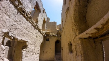 Güneşli baharda Umman 'ın Nizwah kenti yakınlarındaki terk edilmiş kerpiç köyünün fotoğrafları.