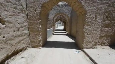 Güneşli baharda Umman 'ın Nizwah kenti yakınlarındaki terk edilmiş kerpiç köyünün fotoğrafları.
