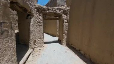 Güneşli baharda Umman 'ın Nizwah kenti yakınlarındaki terk edilmiş kerpiç köyünün fotoğrafları.