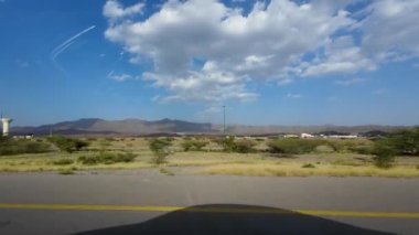 Umman 'daki kurak dağ manzarasının güneşli bahar gününde bir arabadan çekilmiş görüntüsü.