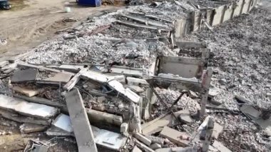 Güneşli bahar gününde bir binayı yıkan makinelerin insansız hava aracı görüntüleri.