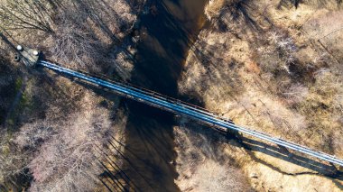Eski boru hattının güneşli bahar günlerinde arazi boyunca giden insansız hava aracı fotoğrafları