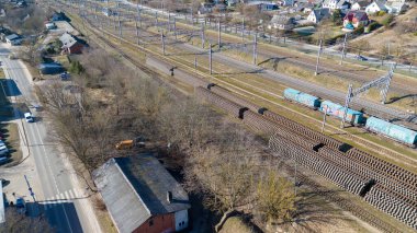 Güneşli bahar aylarında yük arabaları ve yeni demiryolu deposuyla endüstriyel tren istasyonunun insansız hava aracı fotoğrafları.