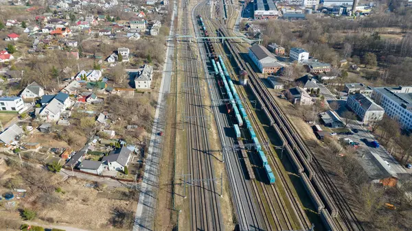 Güneşli bahar aylarında yük arabaları ve yeni demiryolu deposuyla endüstriyel tren istasyonunun insansız hava aracı fotoğrafları.