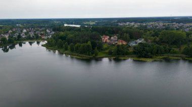 Güneşli yaz günlerinde göllerle çevrili küçük bir kasabanın insansız hava aracı fotoğrafları.