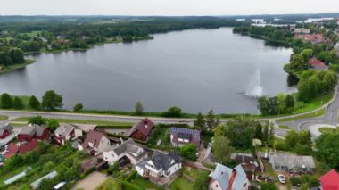 Güneşli yaz gününde göllerle çevrili küçük bir kasabanın insansız hava aracı görüntüleri.
