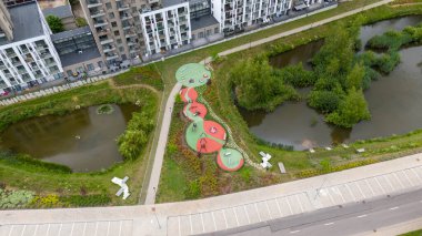 Bulutlu bir yaz gününde göl kenarında bir çocuk oyun parkının drone fotoğrafçılığı