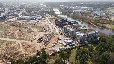 Güneşli yaz günlerinde bir şehirde inşaat şantiyesi ve inşaat makinelerinin insansız hava aracı fotoğrafları
