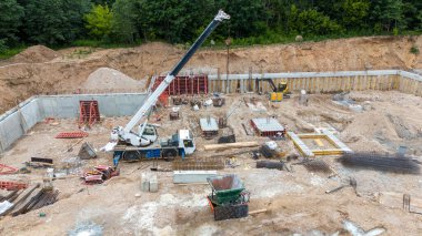 İnşaat alanının insansız hava aracı fotoğrafları, inşaat malzemeleri ve makineleri yaz bulutlu akşamlarda