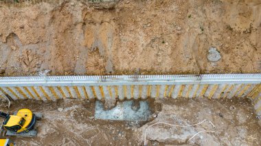 İnşaat alanının insansız hava aracı fotoğrafçılığı ve yaz bulutlu akşamlarda bir temel duvarı