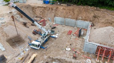 İnşaat alanının insansız hava aracı fotoğrafları, inşaat malzemeleri ve makineleri yaz bulutlu akşamlarda