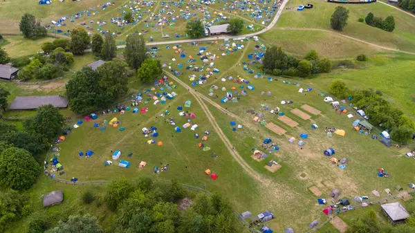 Bulutlu bir yaz günü müzik festivalinde bir çadır şehrinin insansız hava aracı fotoğrafçılığı