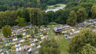 Yaz bulutlu bir günde ormanla çevrili bir mezarlığın insansız hava aracı fotoğrafçılığı