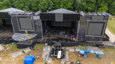 Çöpleri temizleyen gönüllülerin insansız hava aracı fotoğrafları ve bulutlu yaz günlerinde müzik festivalinden sonra müzik sahnelerini söken insanlar.