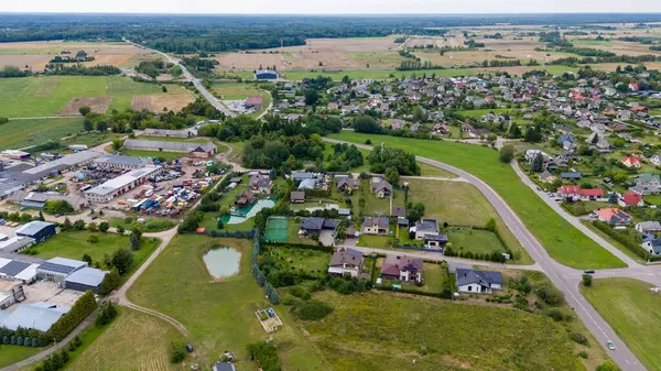 stock image Drone photography of small town surrounded by forest during summer cloudy dusk