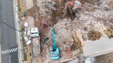 Bir evi söken ve güneşli yaz gününde rubleyi kaldıran makinelerin uzaktan çekimleri.