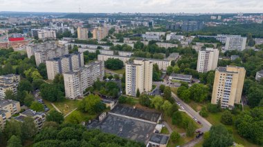 Bulutlu yaz gününde ağaçlarla çevrili eski çok katlı evlerin drone fotoğrafları.