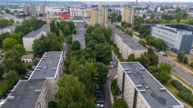 Bulutlu yaz gününde ağaçlarla çevrili eski çok katlı evlerin drone fotoğrafları.