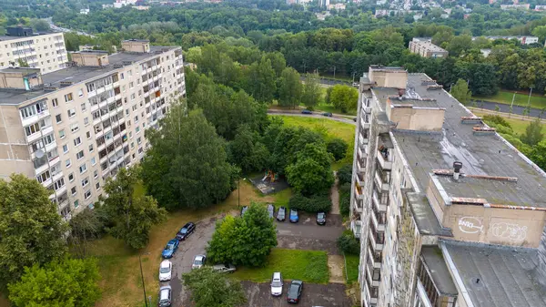 Bulutlu yaz gününde ağaçlarla çevrili eski çok katlı evlerin drone fotoğrafları.