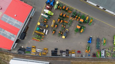 Yazın bulutlu bir günde açık hava deposunda tarım ekipmanlarının drone fotoğrafları.