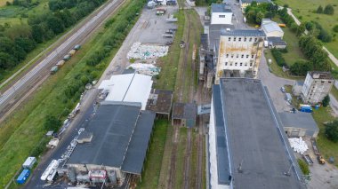 Yaz bulutlu bir günde, demiryolu yakınlarında tahıl ambarı ve fabrikanın insansız hava aracı fotoğrafları.