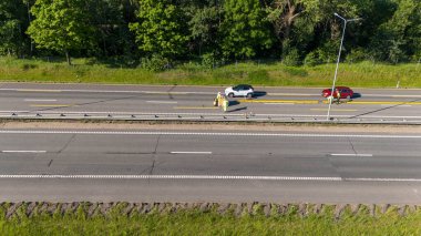 Otoyol ve inşaat işçilerinin tamir ve onarım için yol açtıkları hava manzarası. Yol temiz şeritli ve çevresi yeşillikle çevrili..